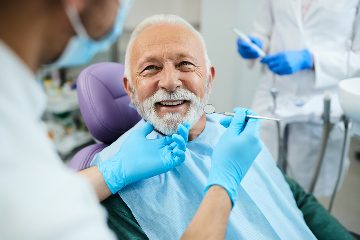 A senior man is getting a dental cleaning