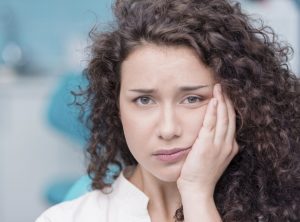 Young woman suffering from toothache