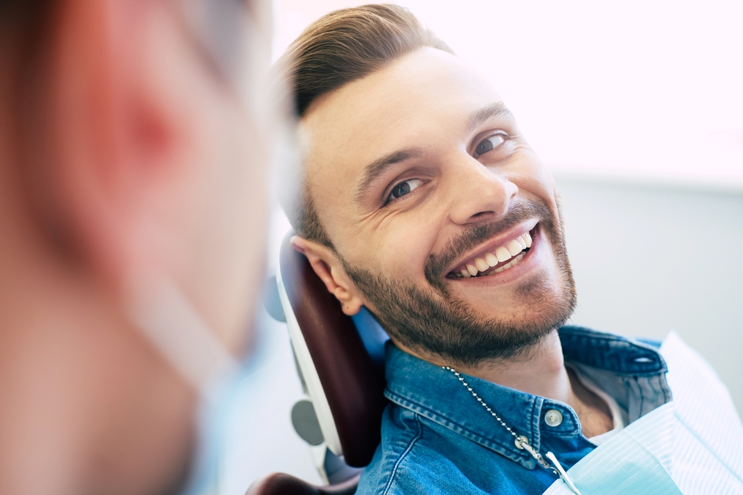 Man in a dental chair smiling at the periodontist