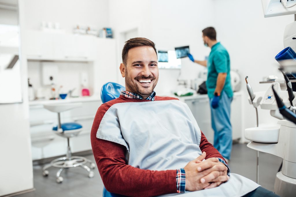 Man sitting in dental chair smiling