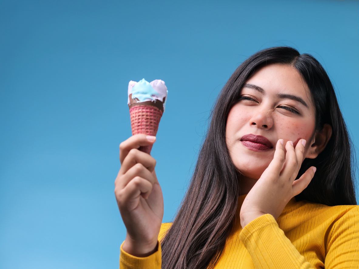 woman with sensitive teeth and cold ice cream cone