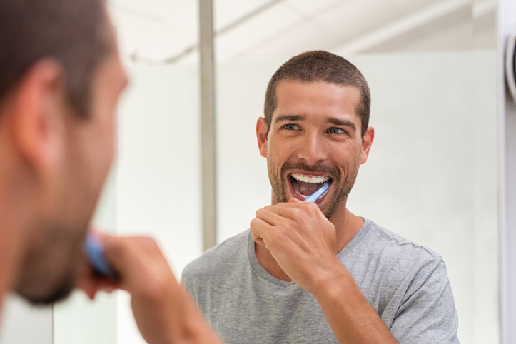 Man brushing his teeth to prevent gum disease.