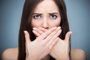 Woman covers her mouth due to gum disease