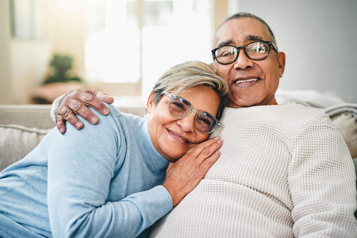 Elderly couple hugging on couch