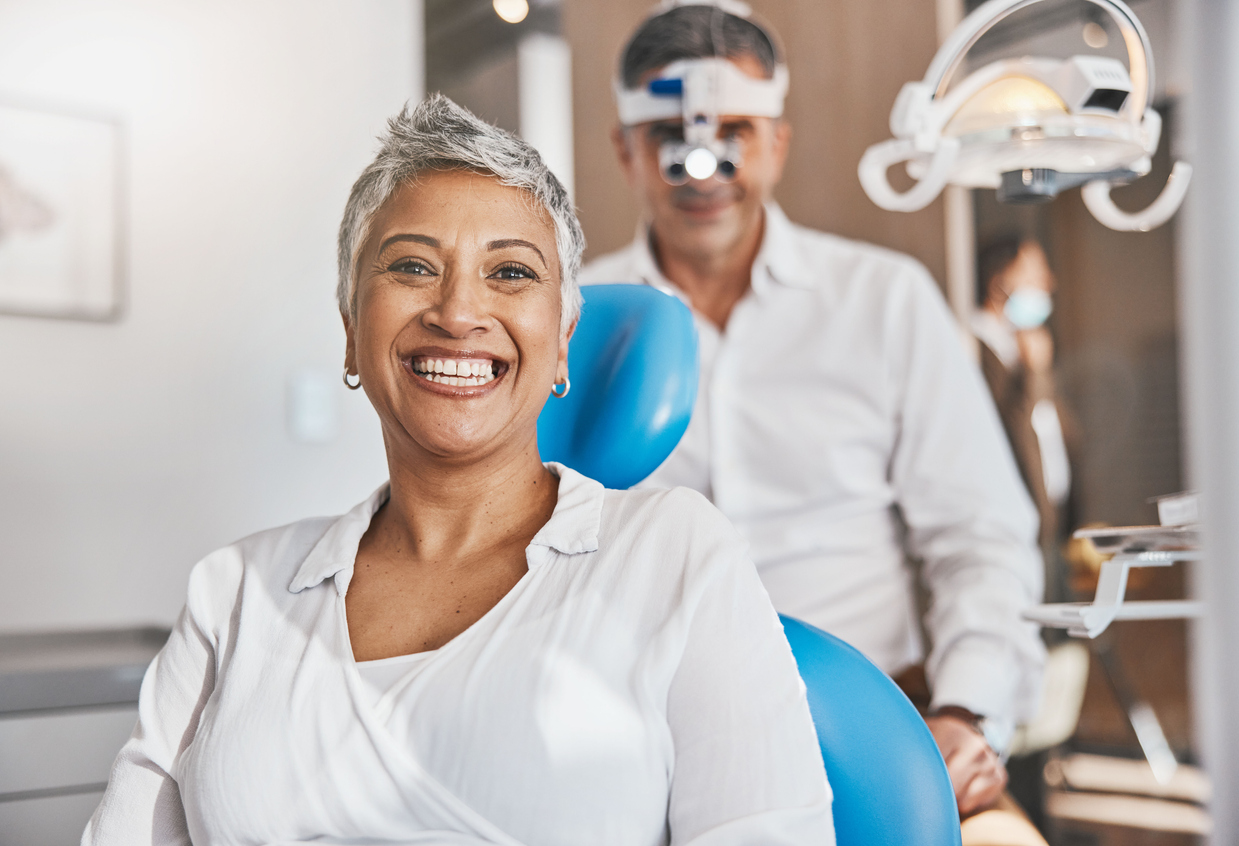 Phoenix implant dentistry. Woman sitting in dental chair with periodontist in background