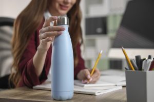 Woman holding a reusable water bottle at work