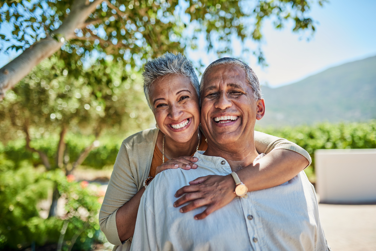 Happy senior couple smiling outside with perfect teeth