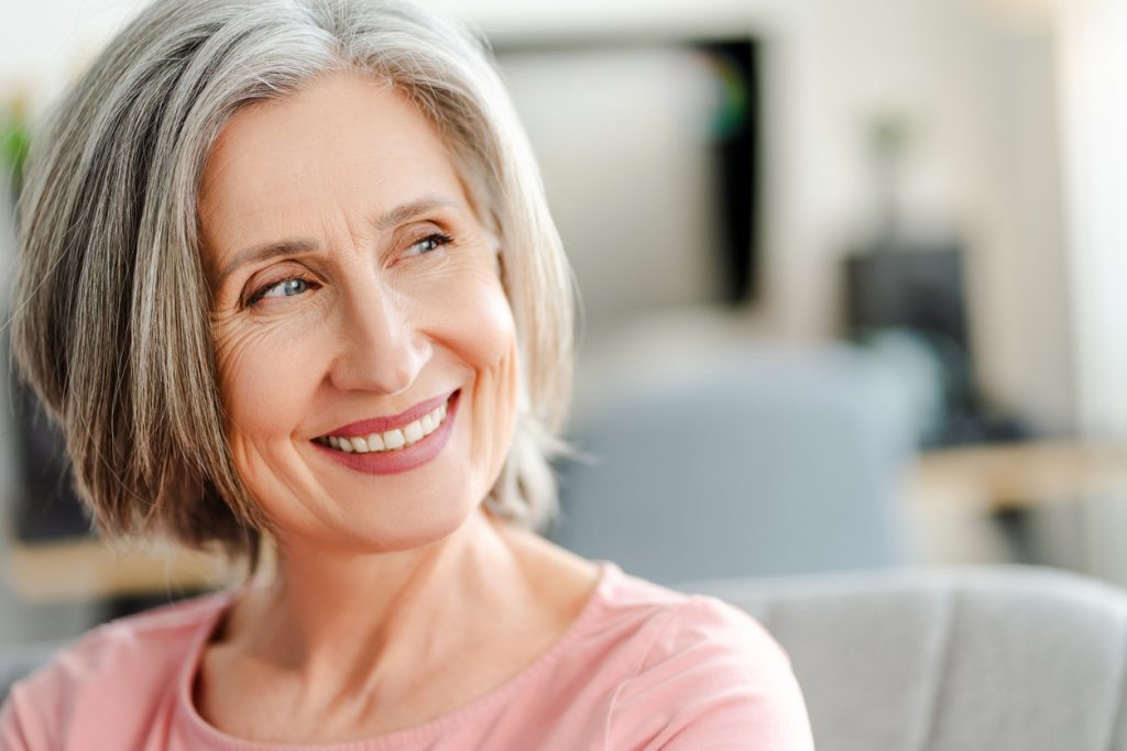 Senior woman smiling. Dental implants improve your health.